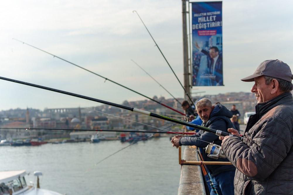 a couple of men standing next to each other on a pier