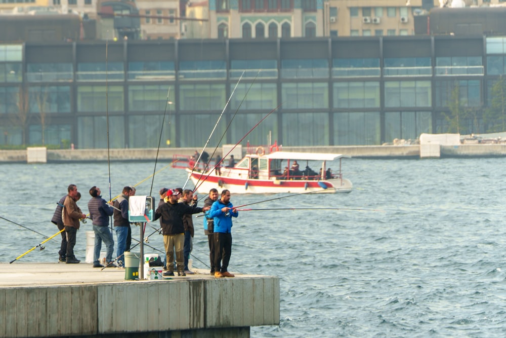 a group of people standing on a pier fishing