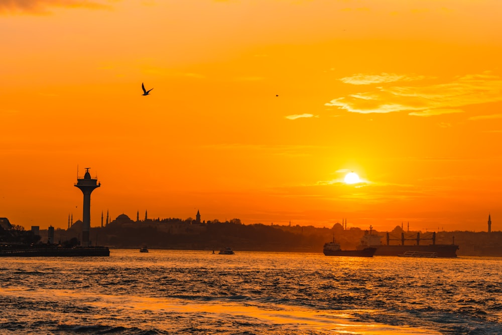 a large body of water with a sunset in the background