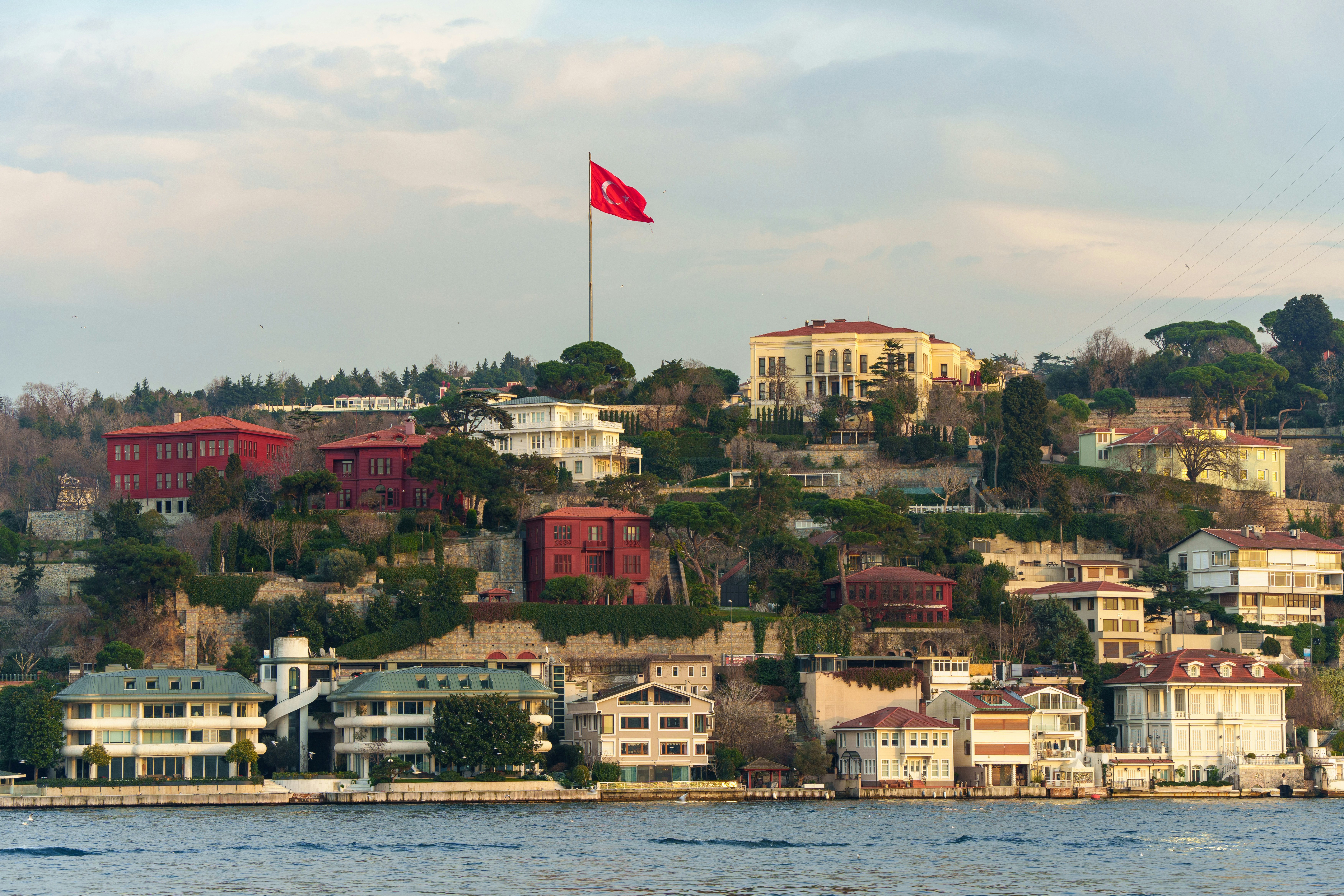 a large body of water with houses on a hill in the background