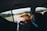 A happy person enjoying music while driving in a scenic landscape.