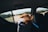 A happy person enjoying music while driving in a scenic landscape.