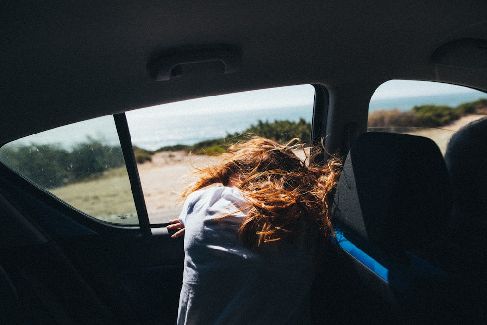 a woman sitting in the back seat of a car