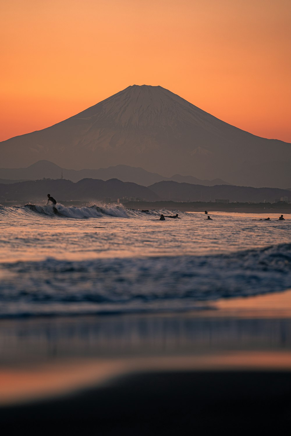 a group of people riding surfboards on top of a wave