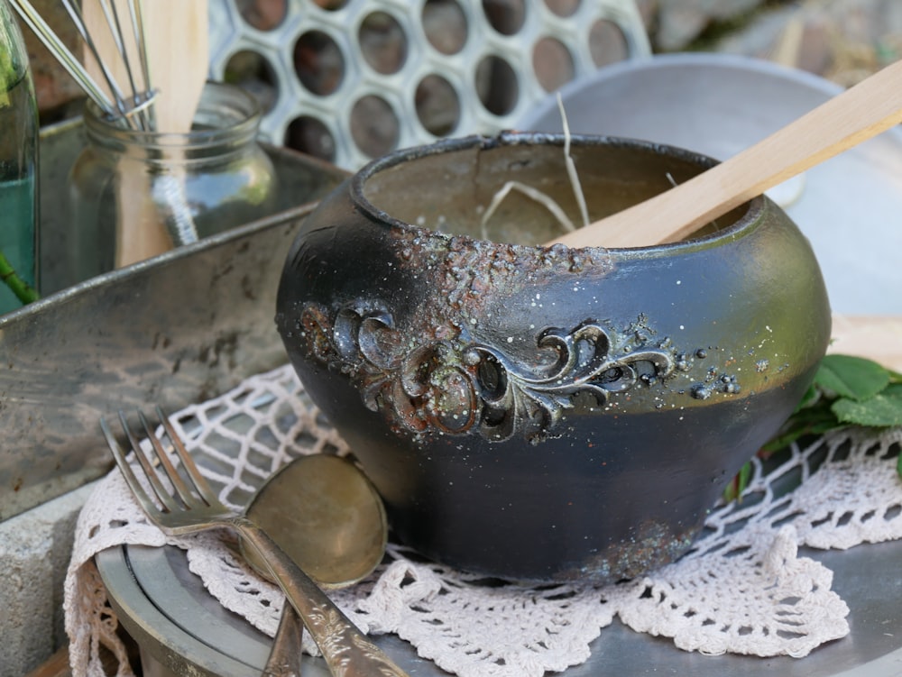 a black bowl with a wooden spoon in it