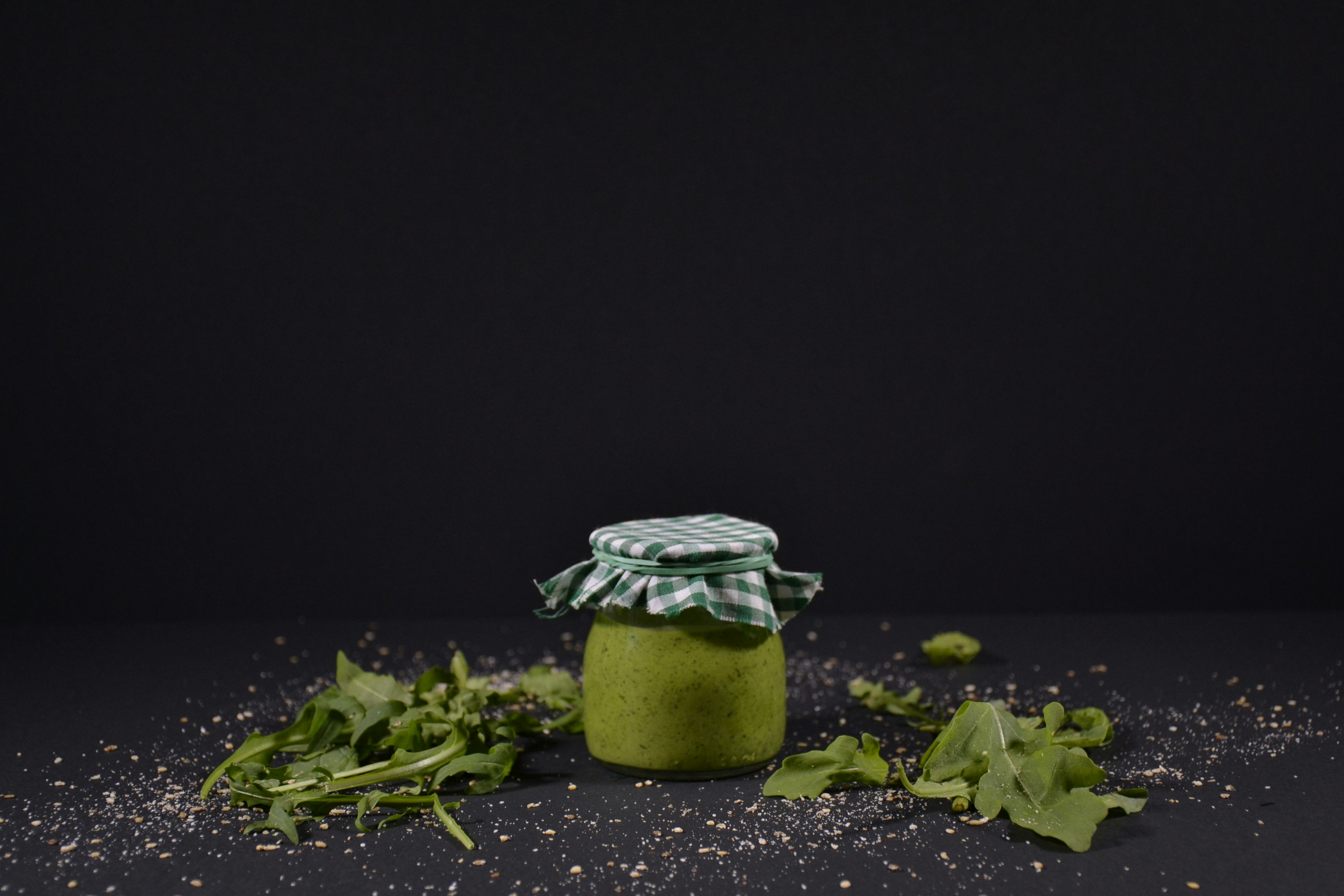 a jar filled with green stuff sitting on top of a table