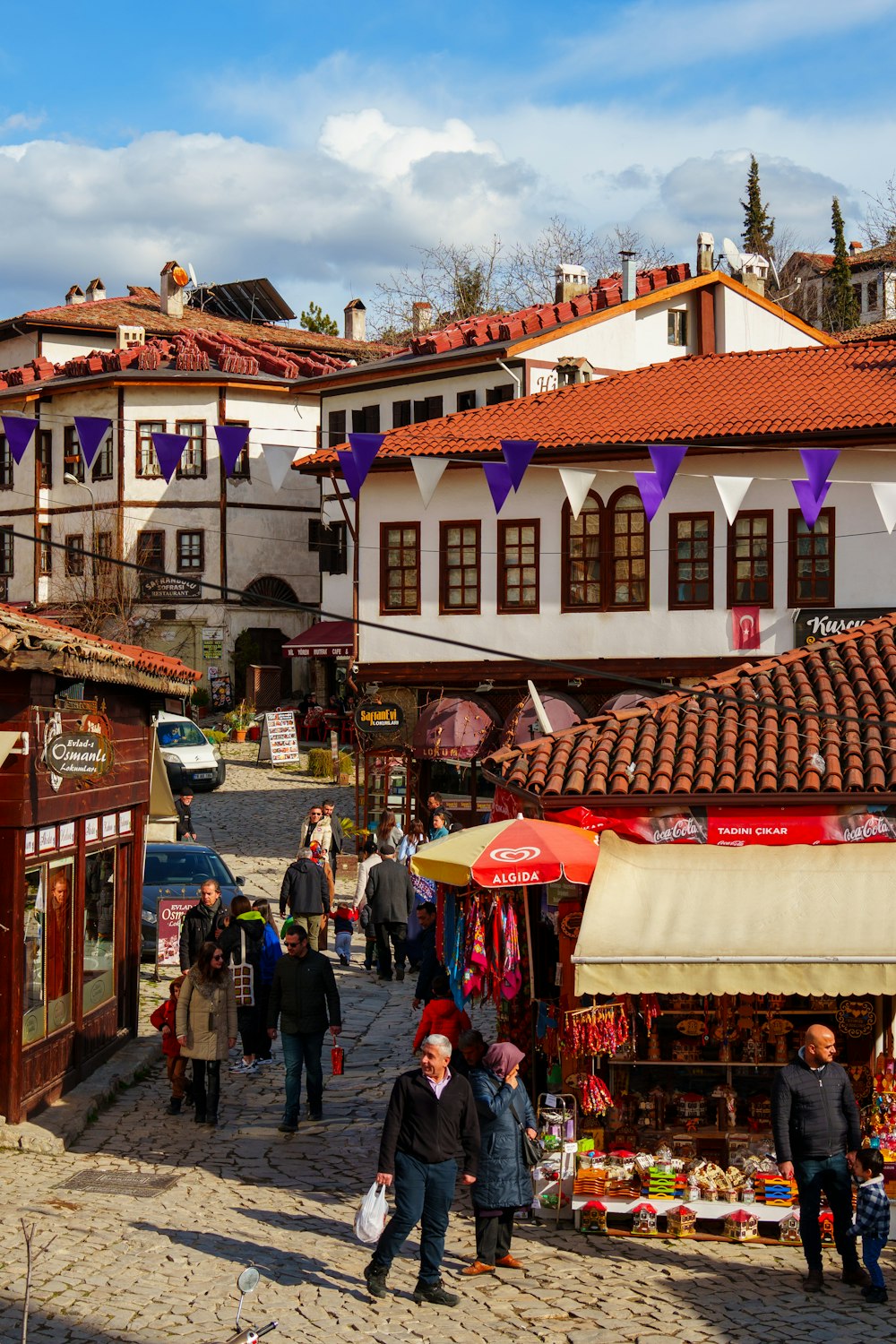 a group of people walking down a street next to buildings