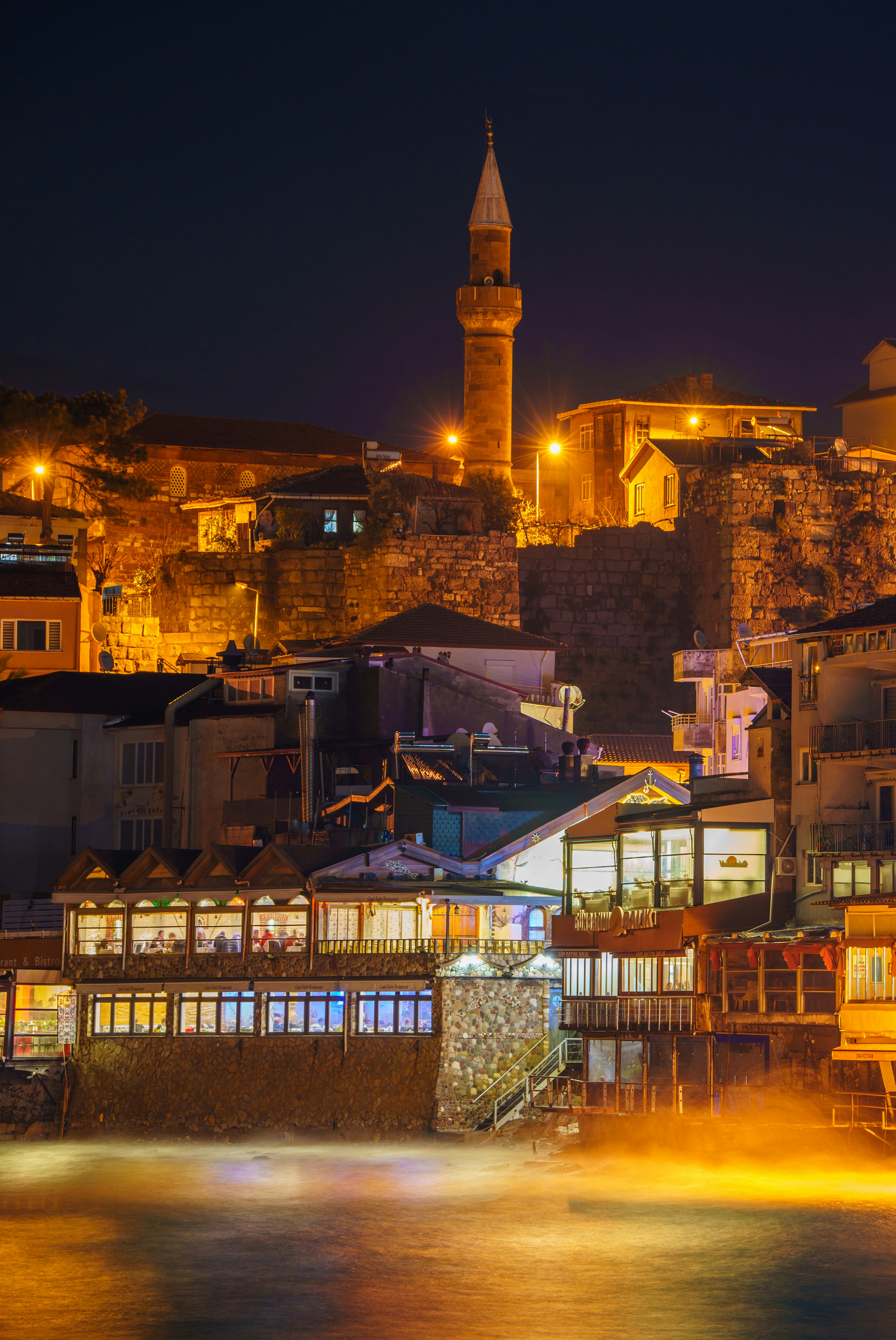 A night view of a city with a clock tower in the background photo ...