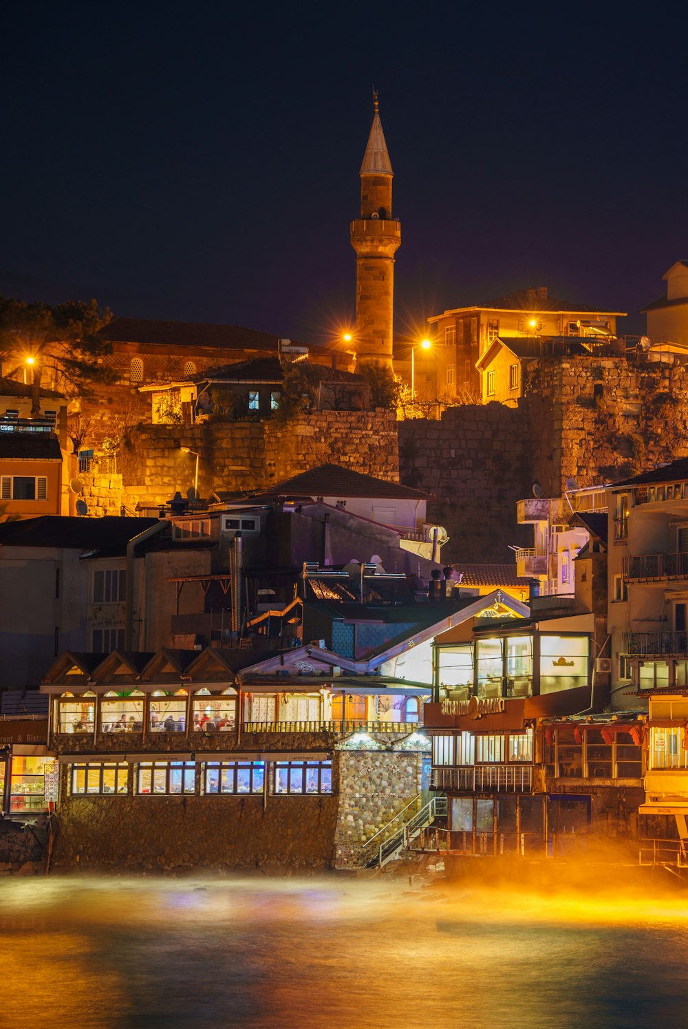 a night view of a city with a clock tower in the background