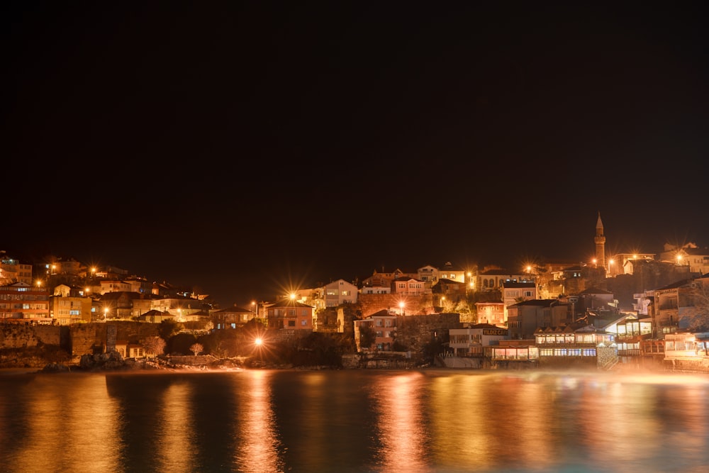 a city lit up at night by the water