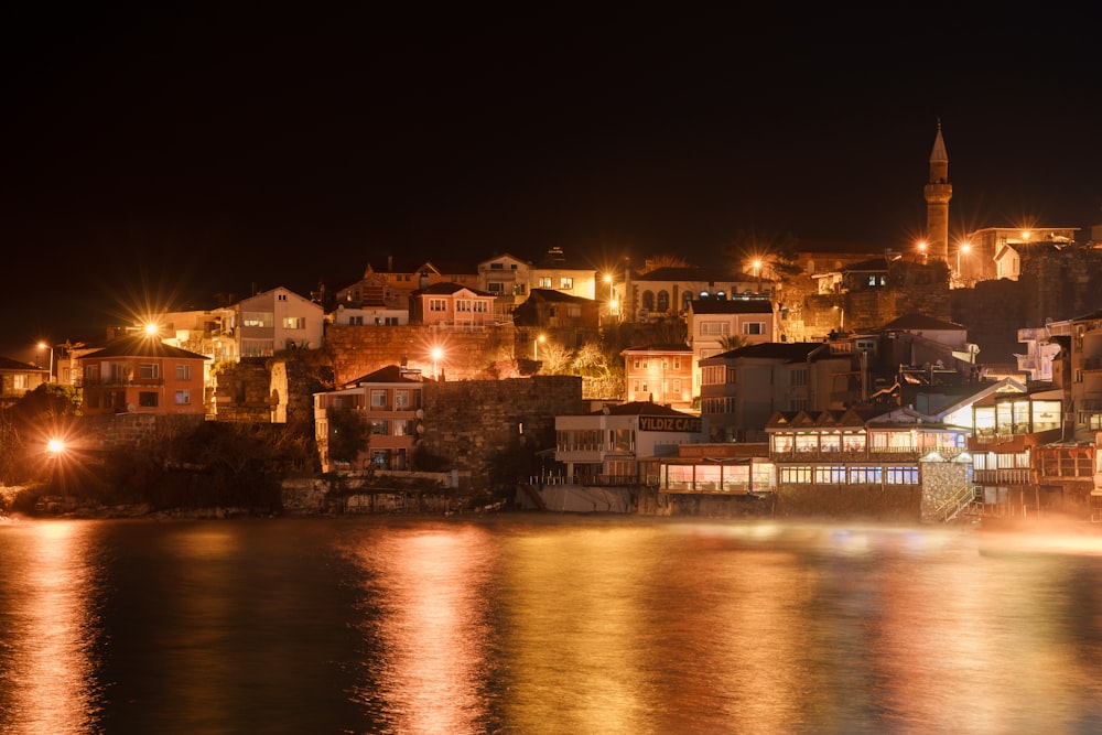 a city lit up at night by the water