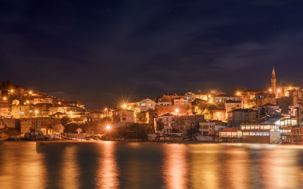 a city lit up at night by the water