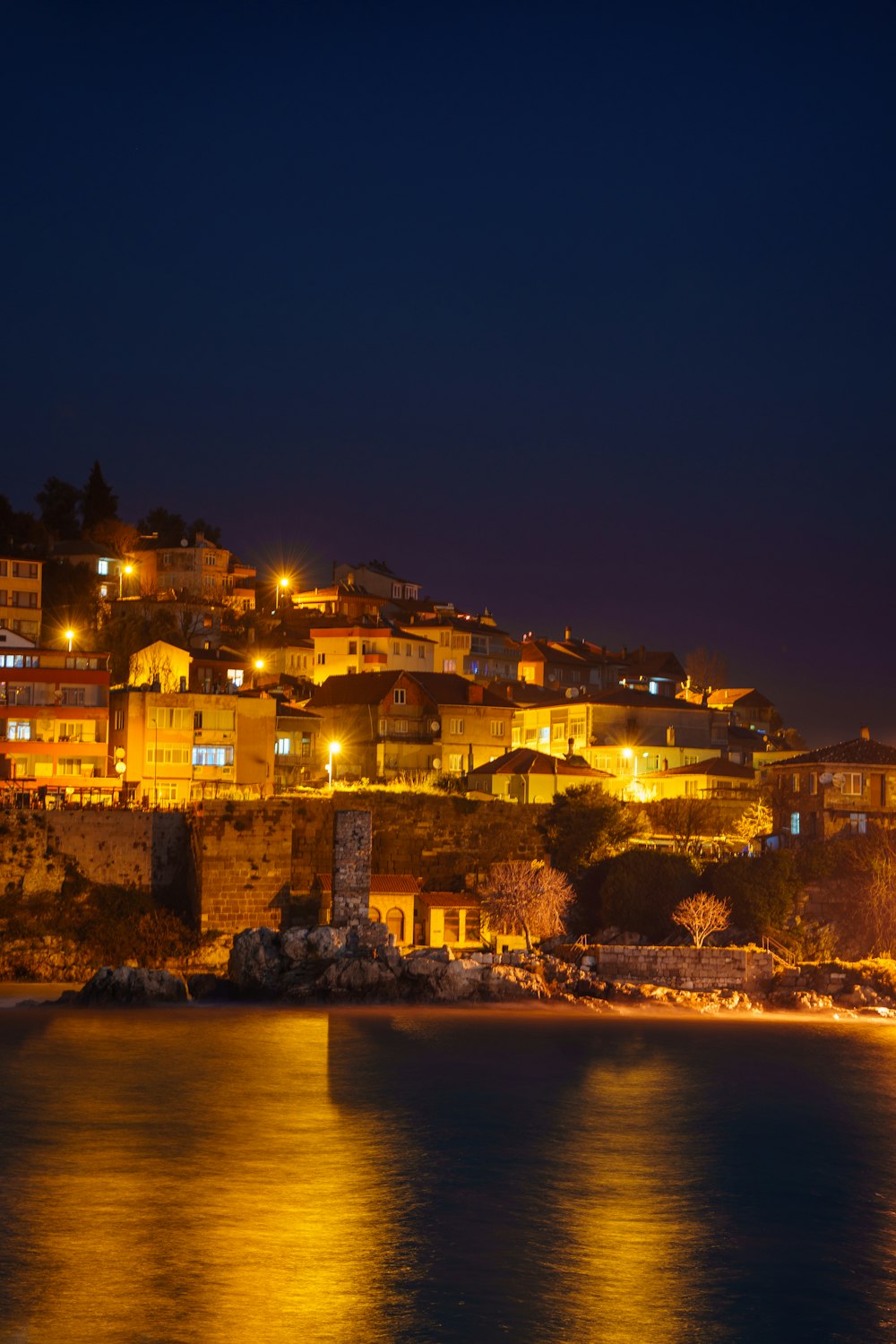 a city lit up at night by the ocean