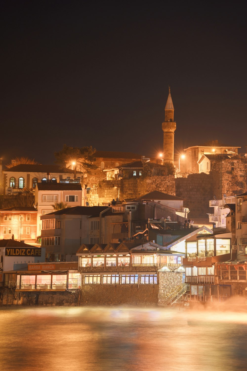 a city at night with a clock tower in the background