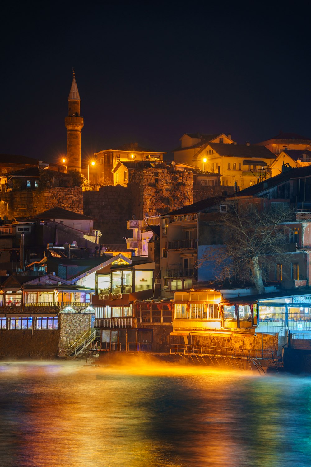 a night view of a city with a clock tower in the background