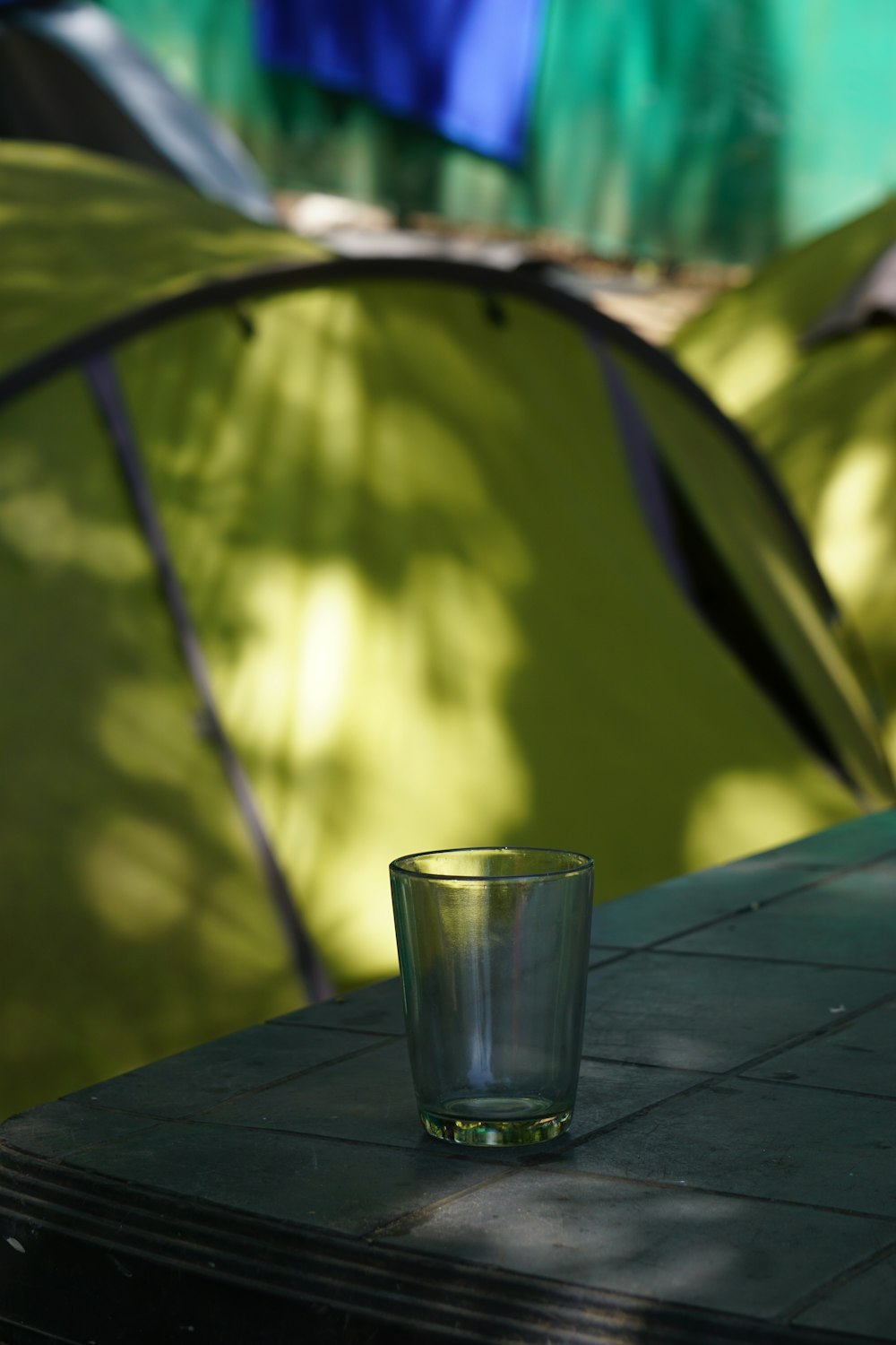 un verre à liqueur posé sur une table devant une tente