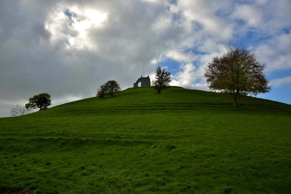 a grassy hill with a house on top of it