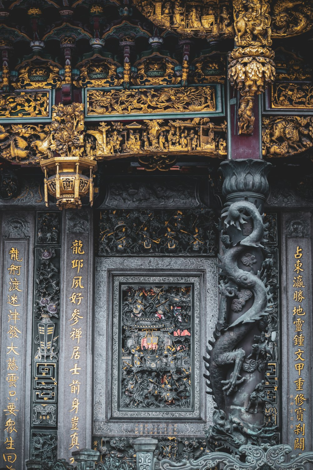 una statua di un drago su un pilastro di fronte a un muro