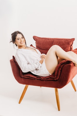 Smiling customer inspecting their freshly cleaned upholstered chair at home.