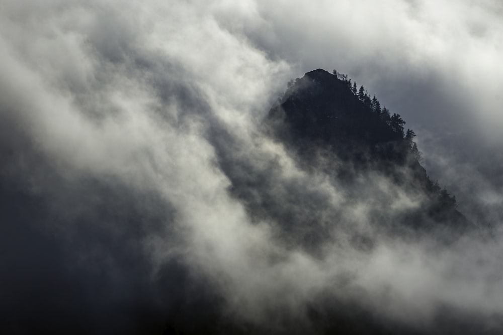 a mountain covered in clouds and trees