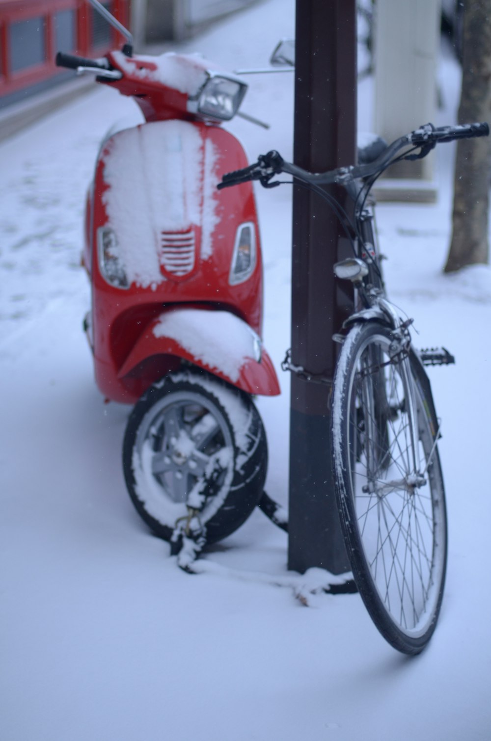 a scooter parked next to a pole covered in snow