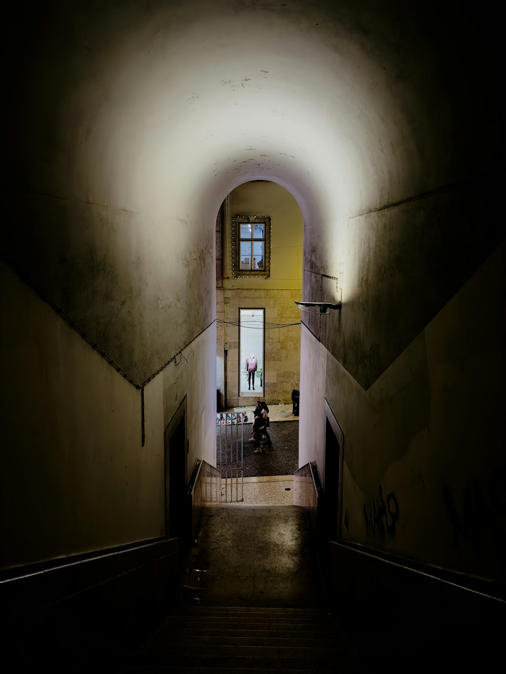 Un túnel oscuro con una persona caminando por él