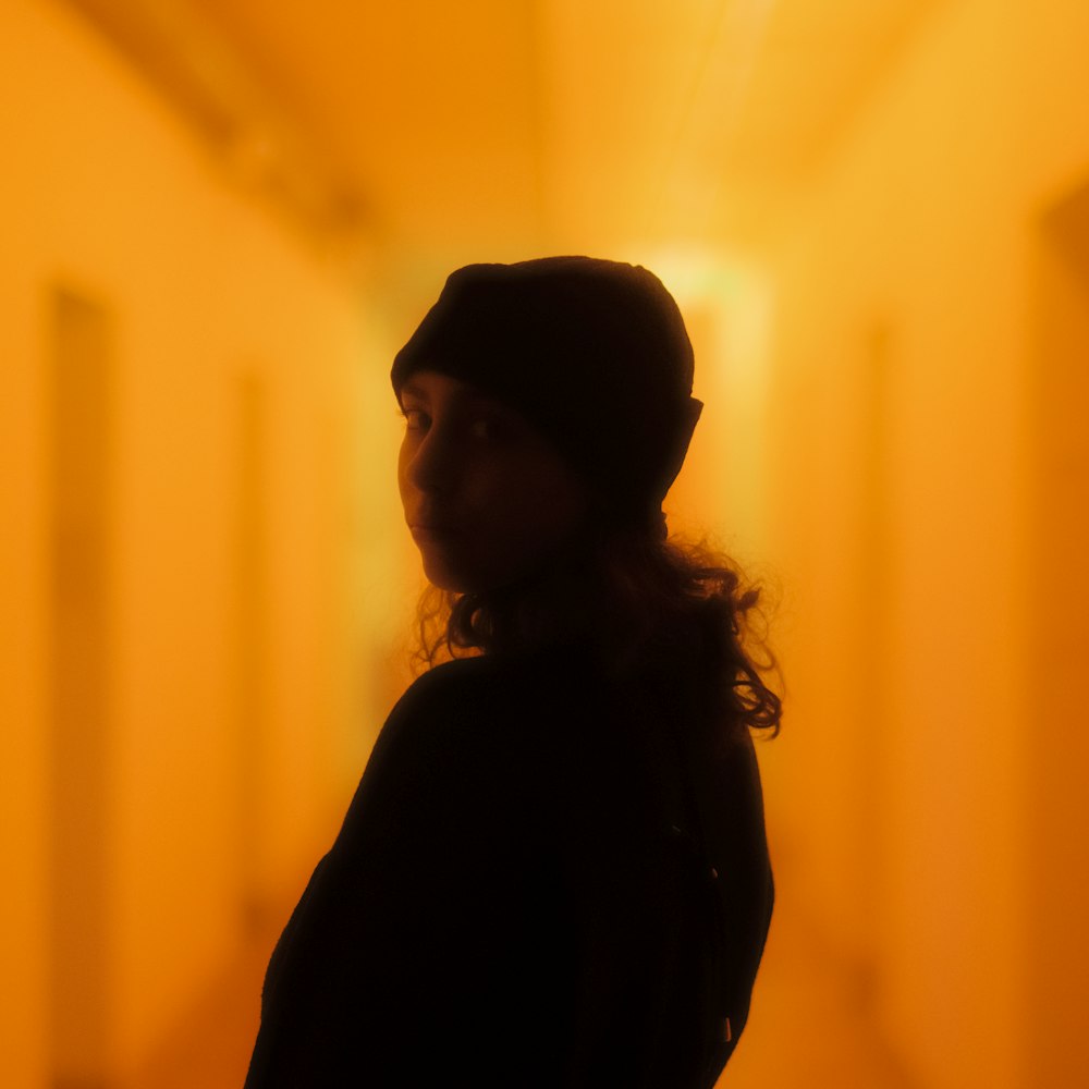 a person standing in a hallway with a hat on