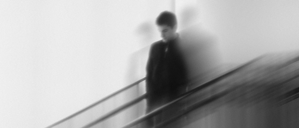 a blurry photo of a man walking down a flight of stairs