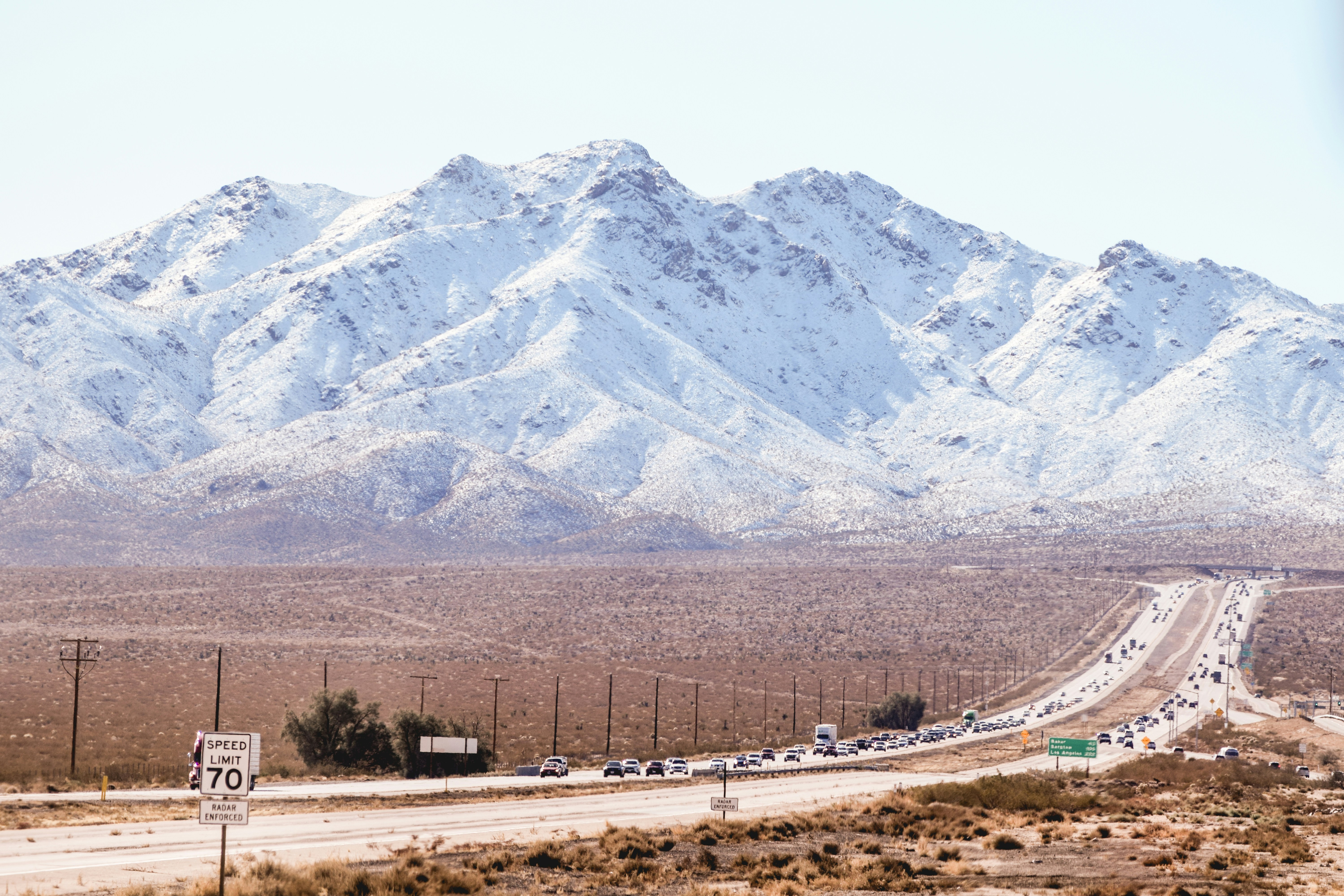 a road with a bunch of cars on it and a mountain in the background
