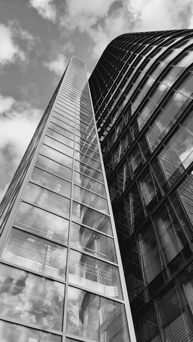 a tall glass building with a sky background