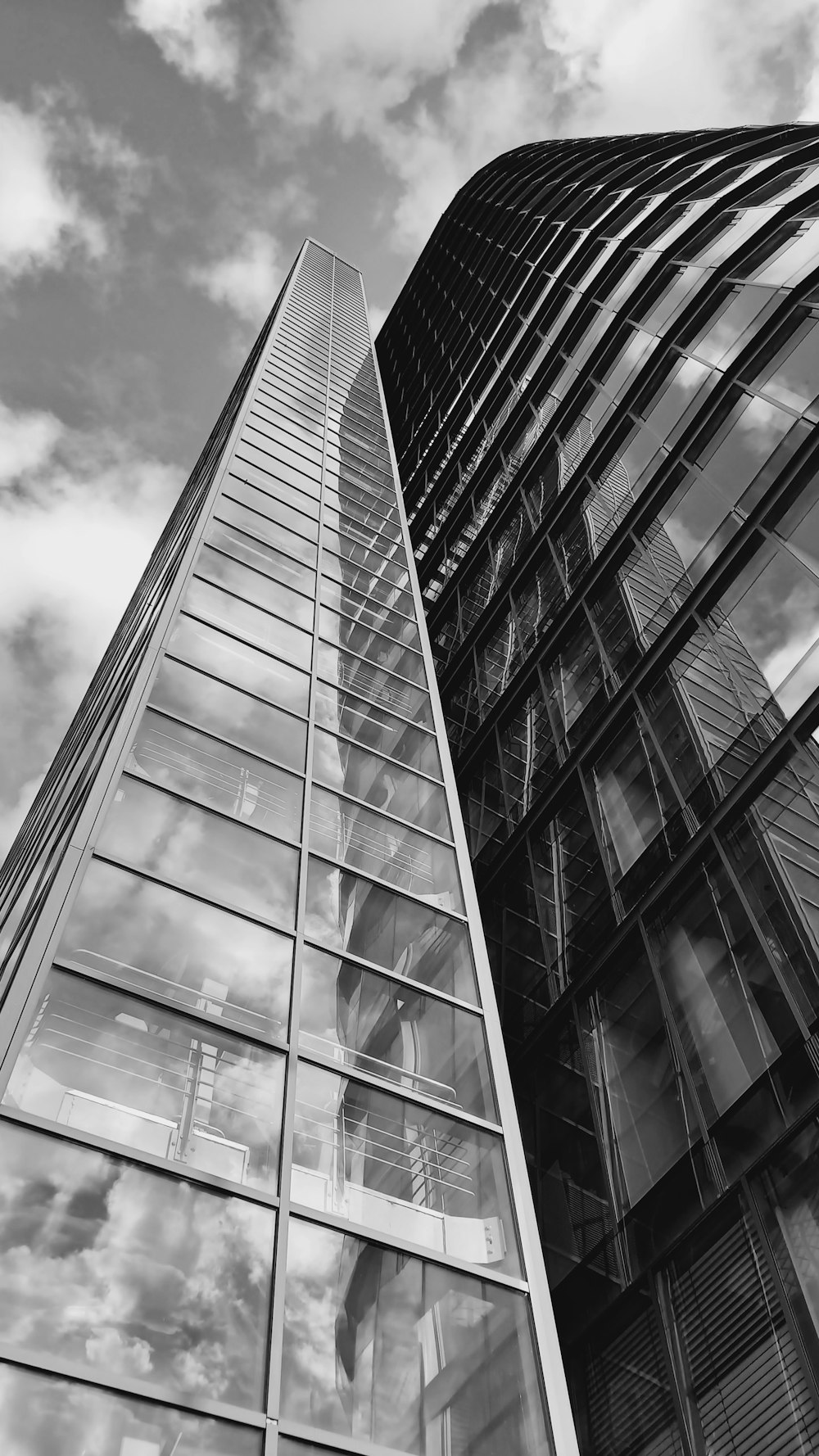 a tall glass building with a sky background