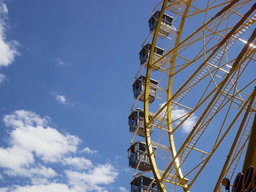 a ferris wheel against a blue sky with clouds