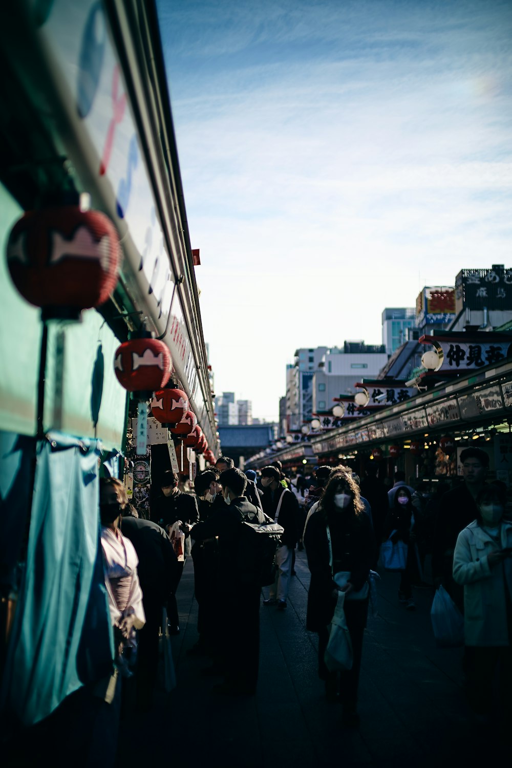 a group of people walking down a street next to tall buildings