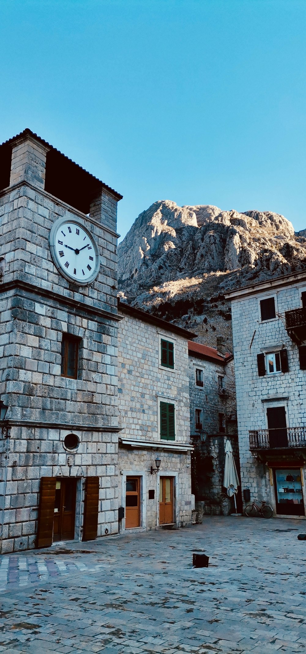 un edificio de piedra con un reloj en el costado