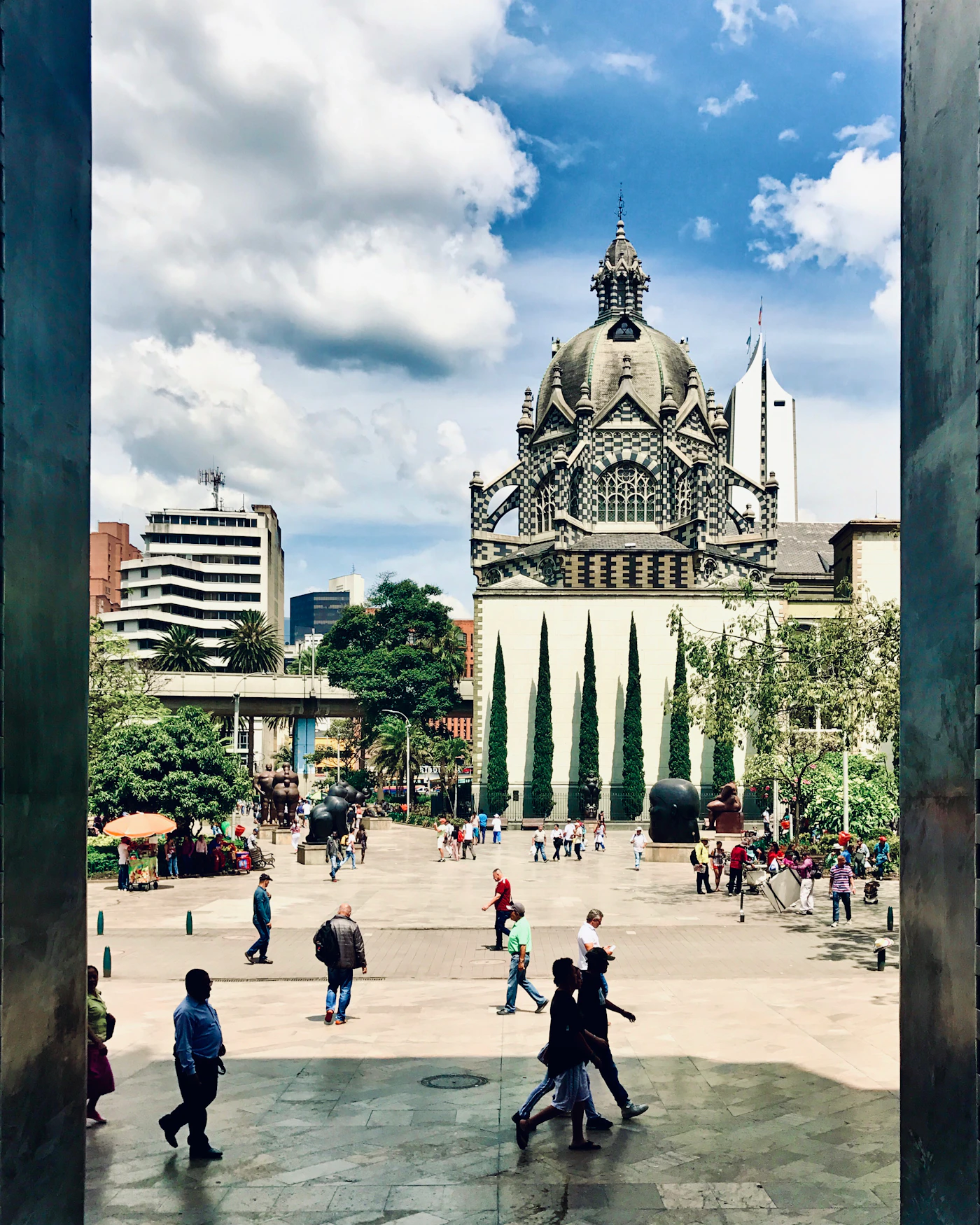 Medellín's El Poblado neighbourhood in afternoon light with tropical trees lining the streets and boutique hotels
