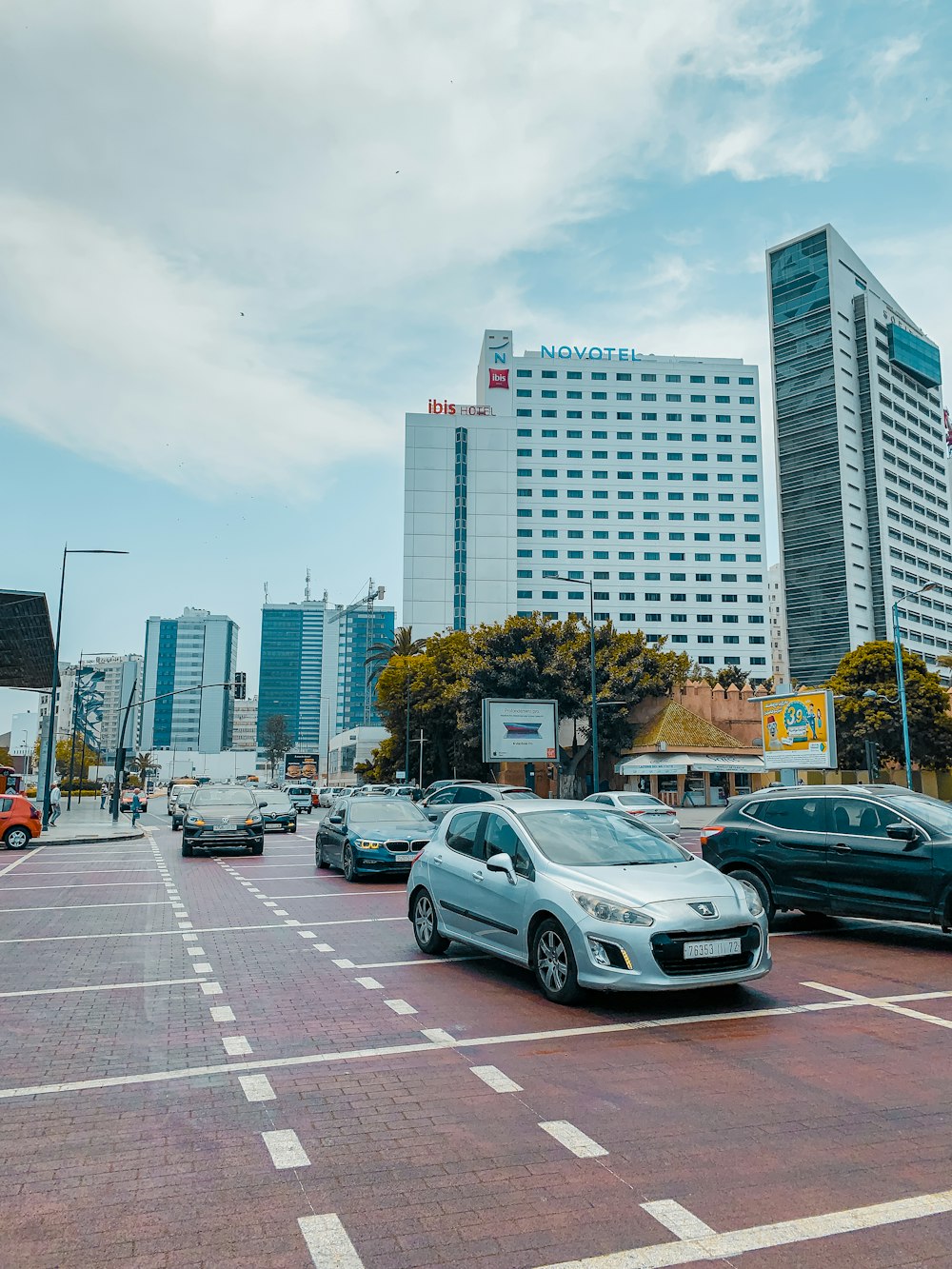 a city street filled with lots of traffic next to tall buildings