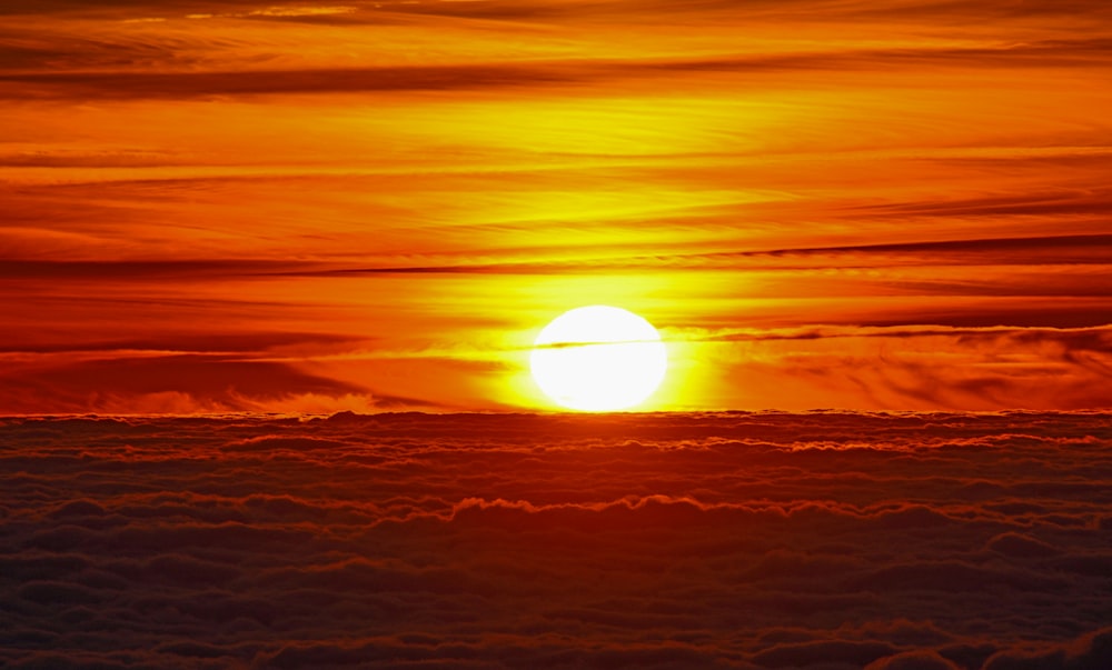 the sun is setting over the clouds in the sky