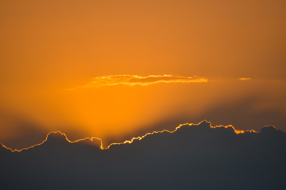 the sun is setting behind the clouds in the sky