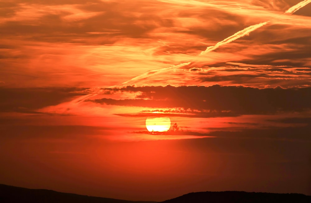 the sun is setting over a mountain range