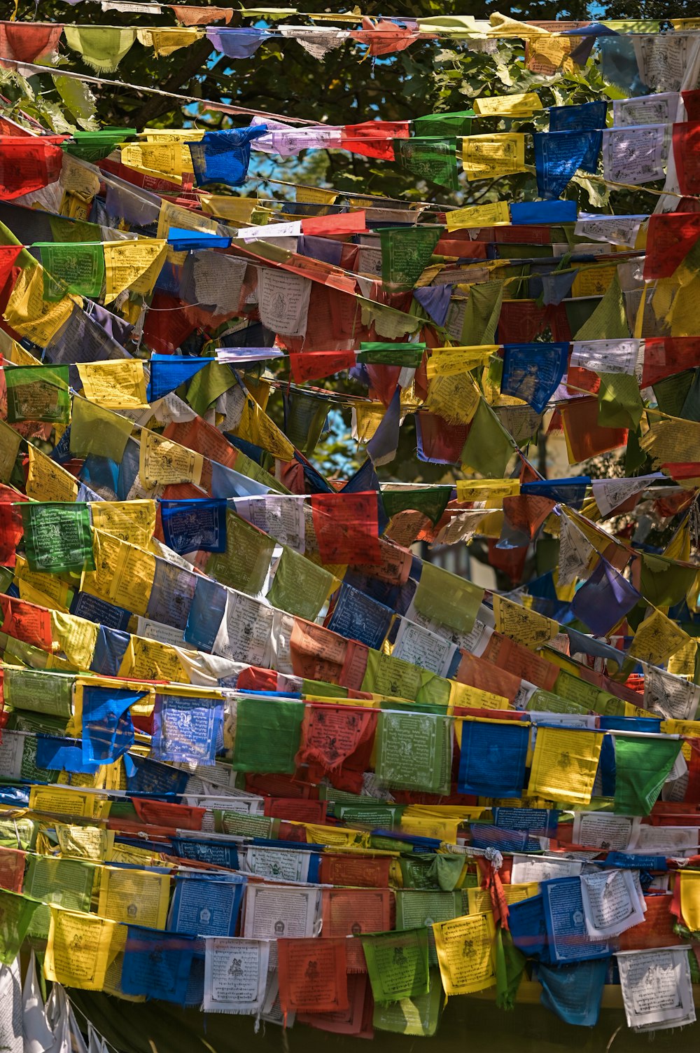 a bunch of colorful flags hanging from the side of a building