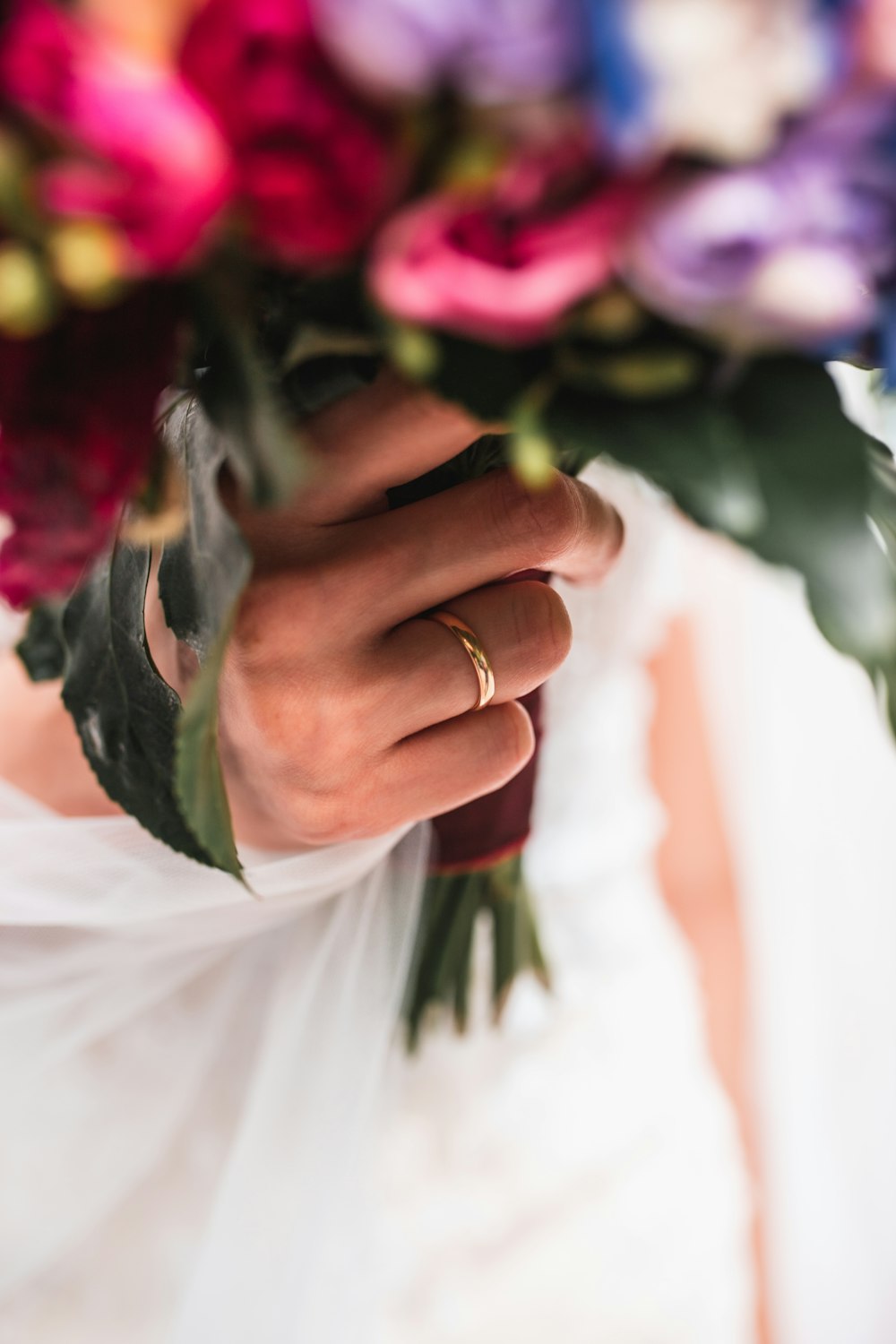 a close up of a person holding a bouquet of flowers