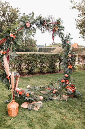 Elegant floral archway decorated with roses and greenery for an outdoor event
