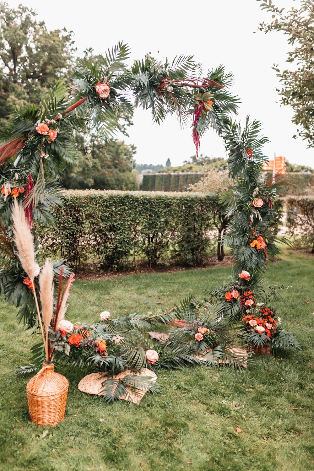a wreath with feathers and flowers on a lawn