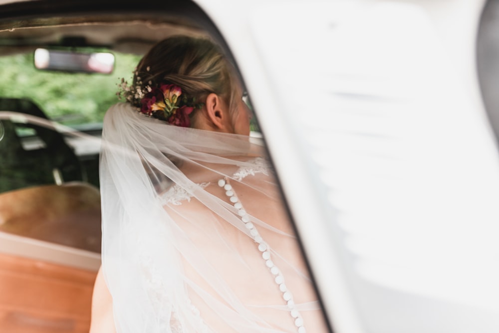 a woman in a car with a veil on her head