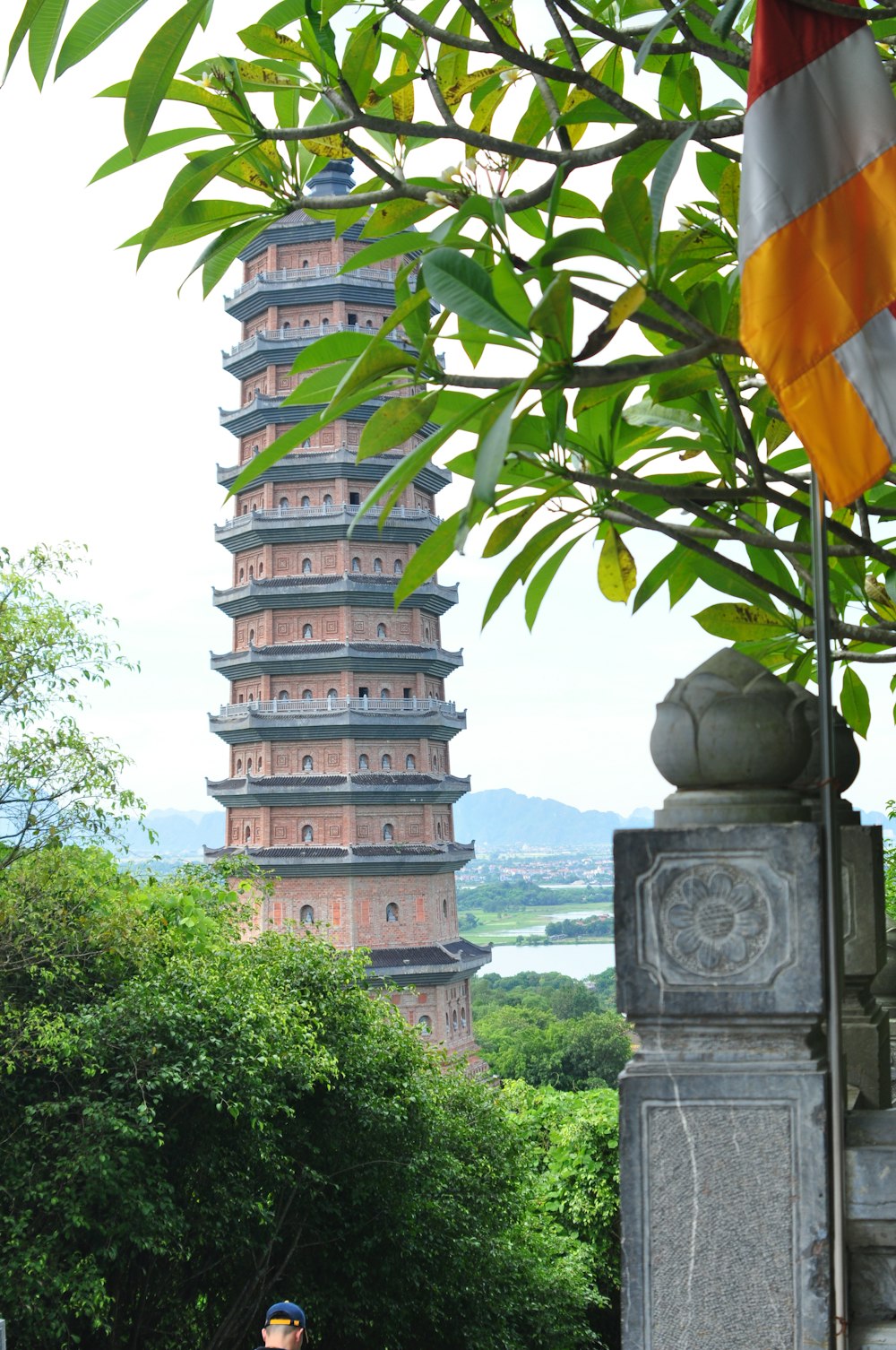 a man riding a bike down a street next to a tall tower