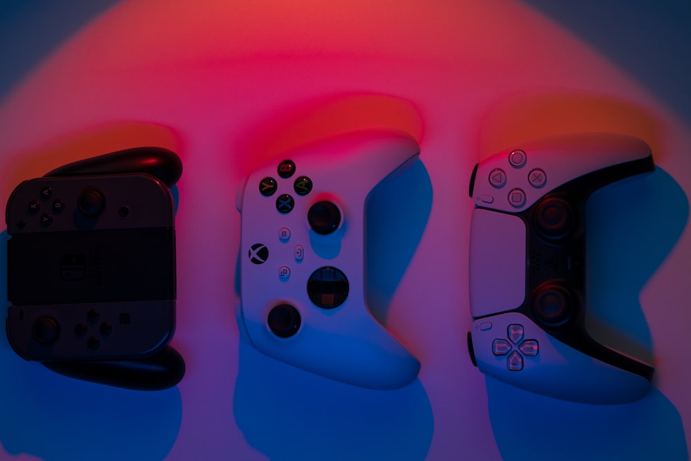 a group of three video game controllers sitting next to each other