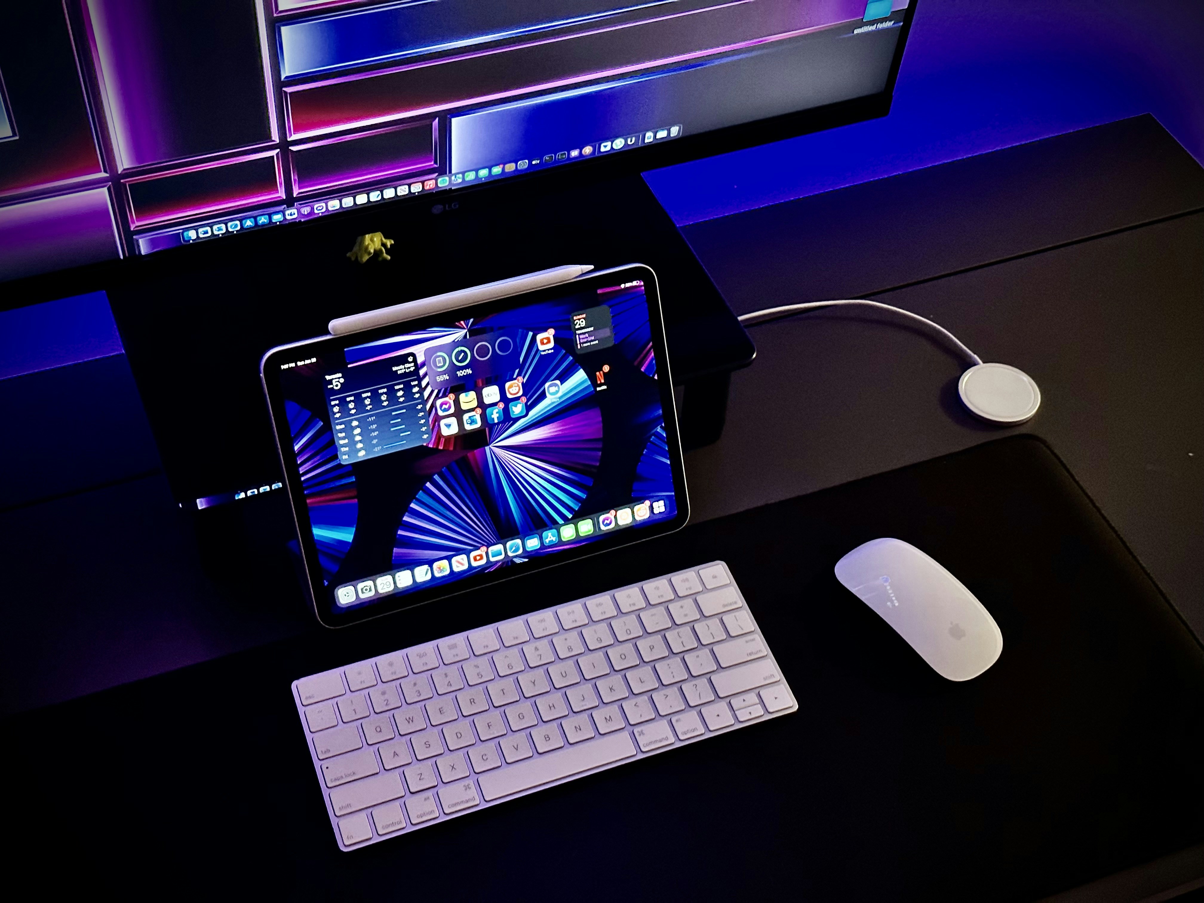a tablet computer sitting on top of a desk next to a keyboard