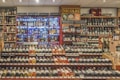 A well-stocked wine and spirits store with numerous bottles of wine displayed on wooden shelves. The shelves feature a range of wines from different regions and spirits in glass bottles, illuminated by soft lighting. Signs indicate different categories such as liqueurs, wines, and special beers.
