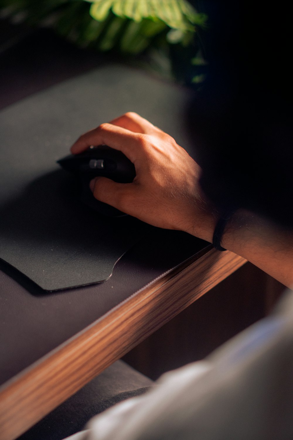 a person's hand on a mouse pad on a desk