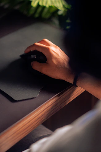 a person's hand on a mouse pad on a desk